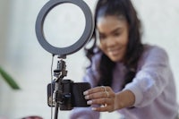 a woman using a ring light to take a selfie